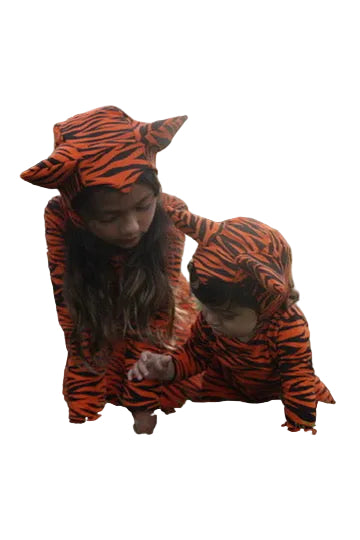 Two children in tiger-striped outfits playing on grass.
