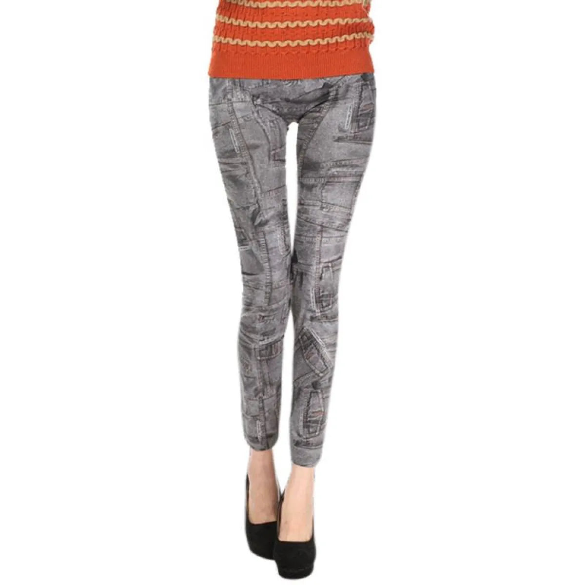 Person wearing gray patterned leggings with an orange sweater on a white background