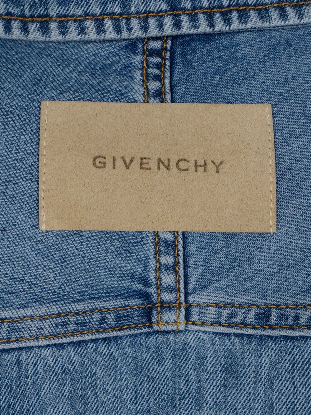 Close-up of a Givenchy label on a blue denim fabric.