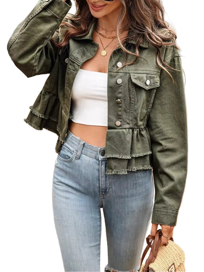 Woman wearing a green jacket, white top, and blue jeans outdoors.