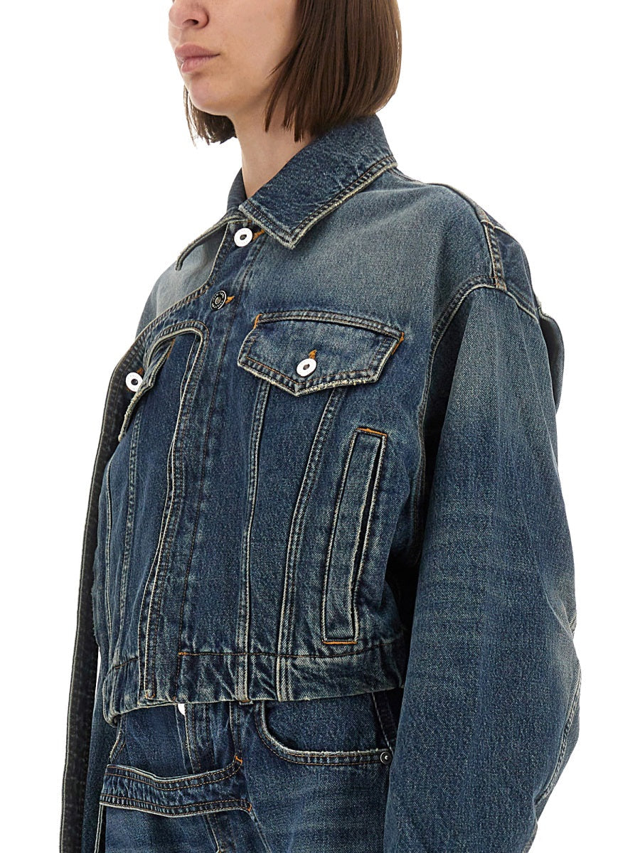 Person wearing a blue denim jacket on a white background