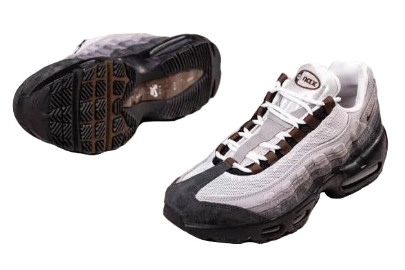A Nike Air Max 95 sneaker in a gray, white, and black colorway, shown from both the side profile and the sole view on a light beige background.