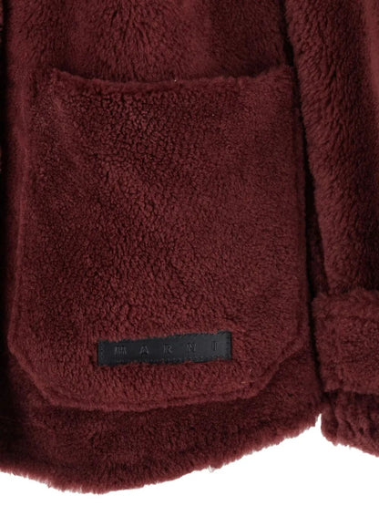 Close-up of a maroon fleece jacket with a brand label on a white background