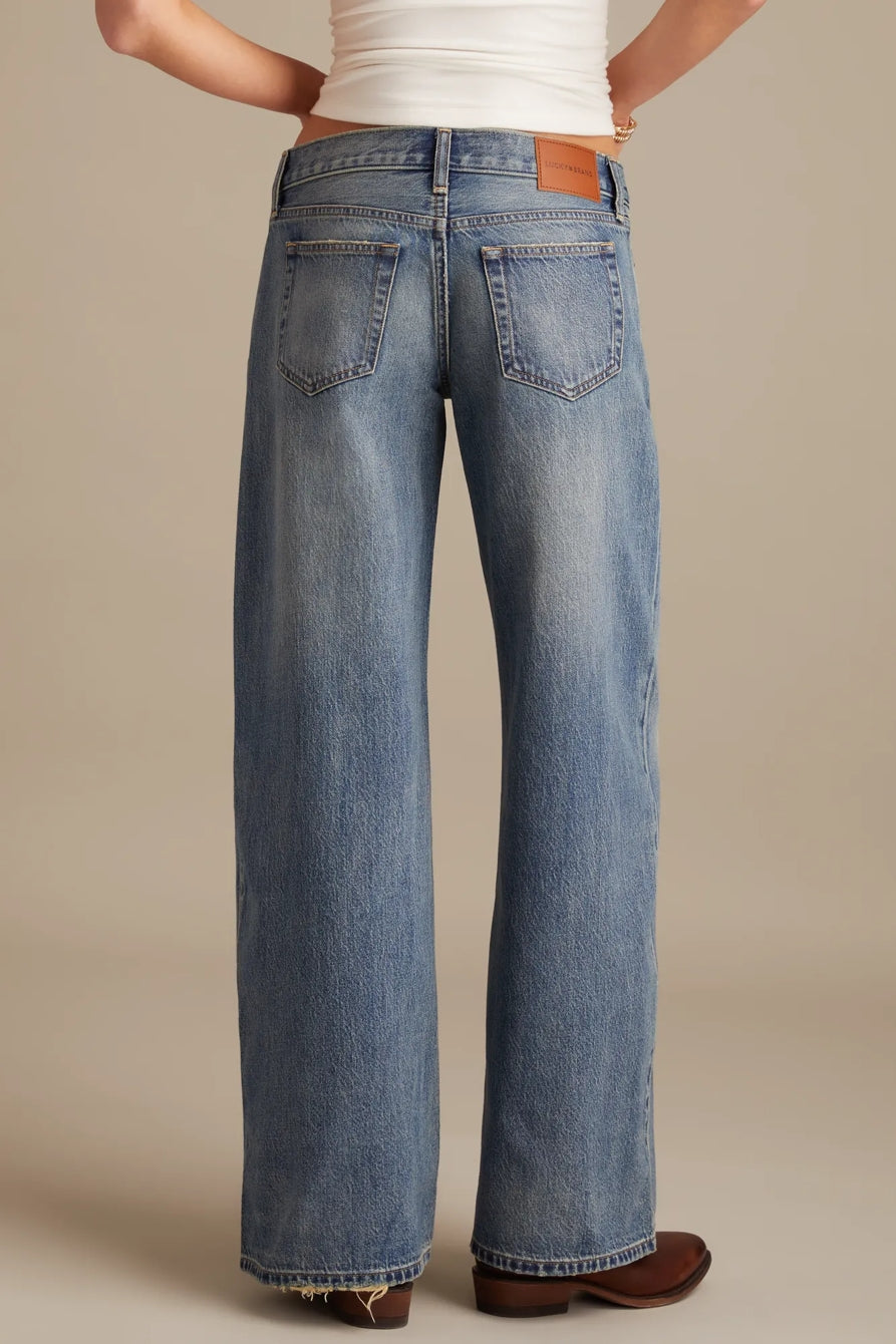 Person wearing blue jeans on a beige background