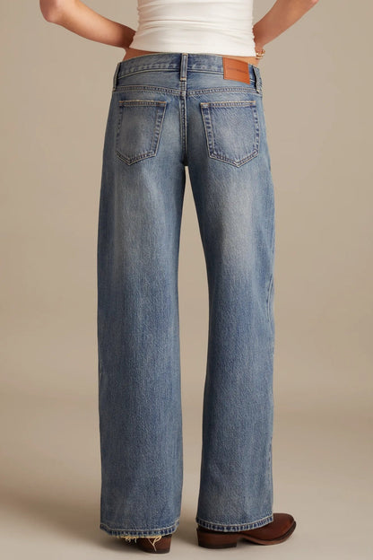 Person wearing blue jeans on a beige background