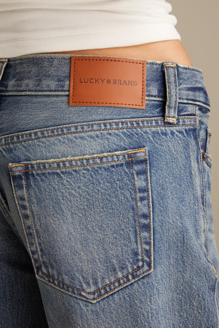 Close-up of blue jeans with a brown Lucky Brand label.