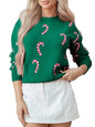 Person wearing a green sweater with candy cane patterns and a white skirt.