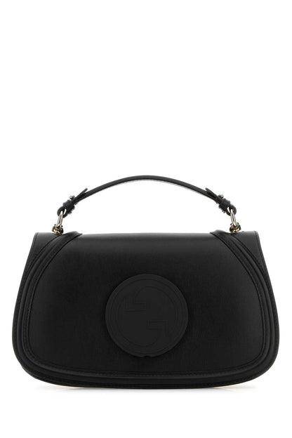 Black handbag with a circular design on a white background