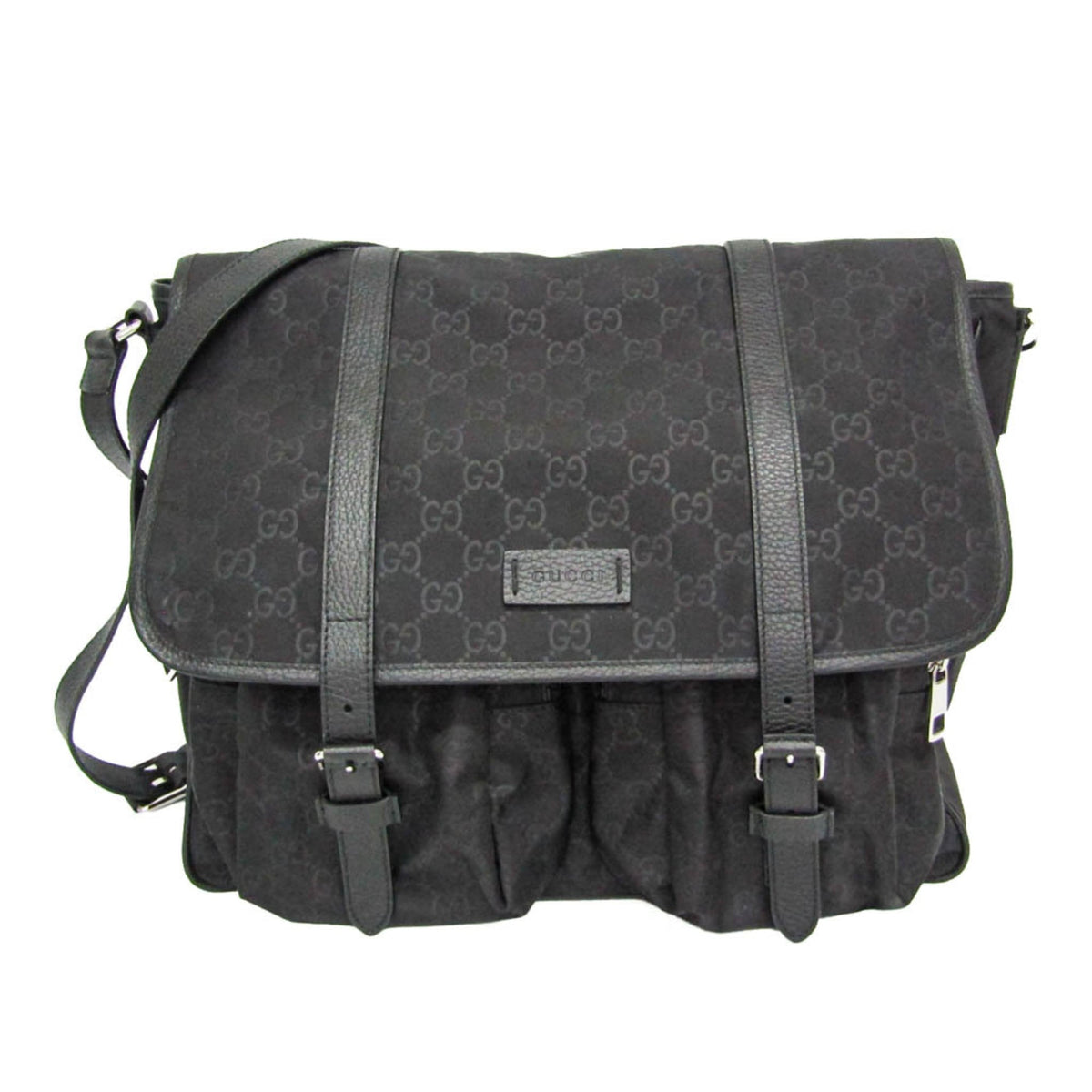 A black Gucci messenger bag featuring the brand's signature GG monogram canvas, black leather straps, and a front flap with a small metal Gucci logo plaque.