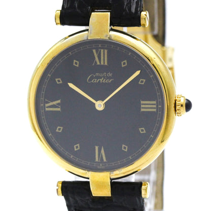 A Cartier watch with a yellow gold case, a dark gray dial with Roman numerals, and a black leather strap, shown against a white background.