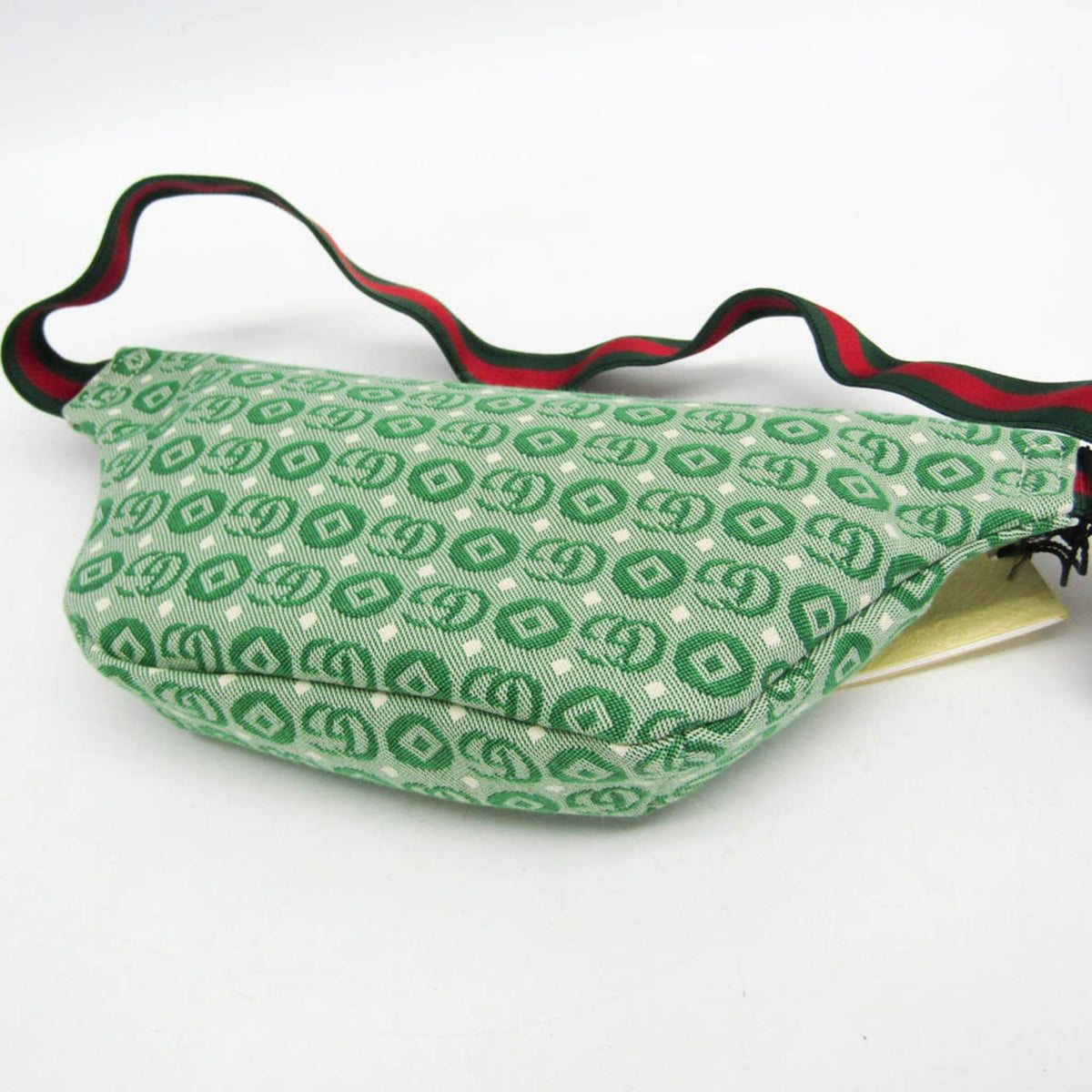 Green patterned bag with a red and black strap on a white background
