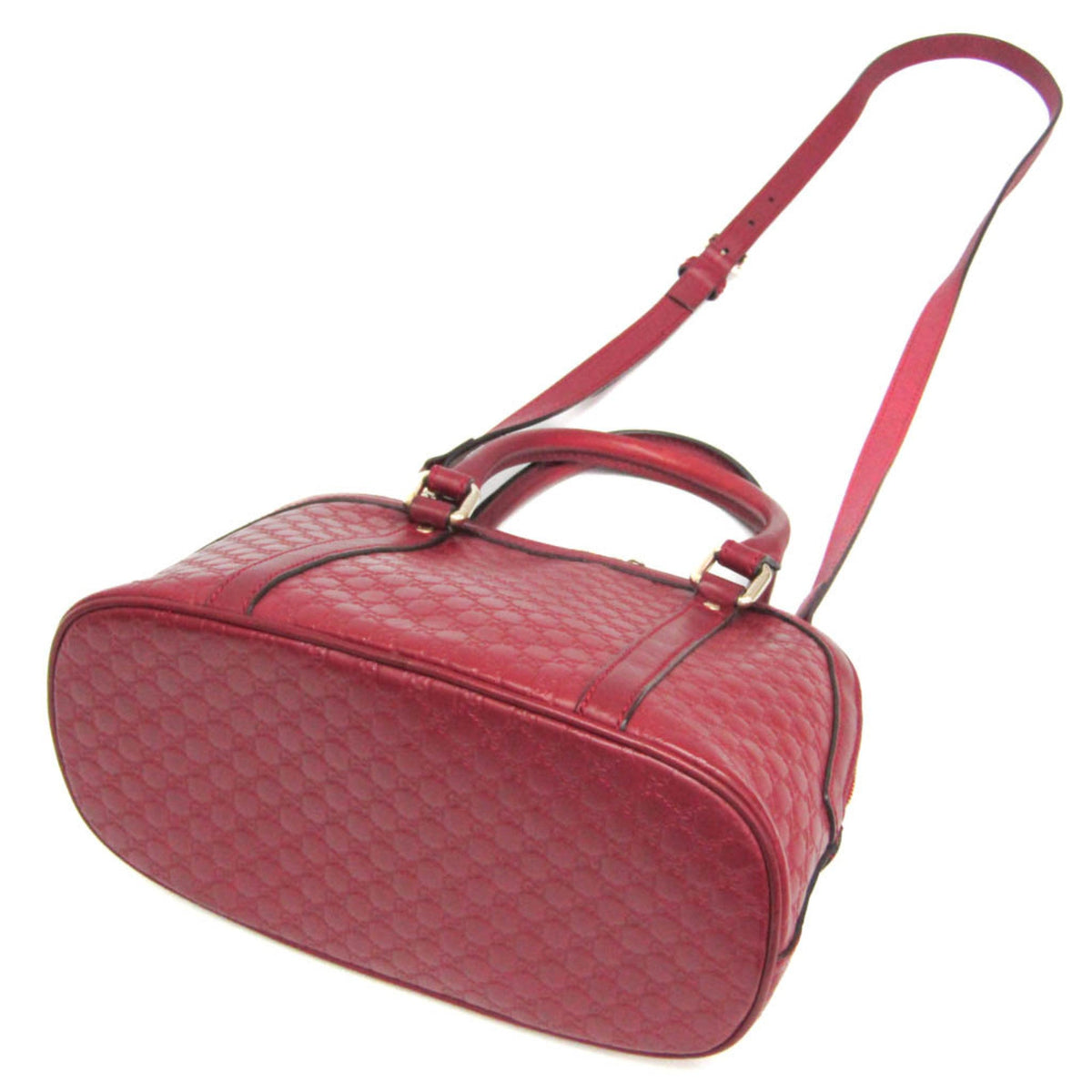 Red handbag with a textured pattern on a white background
