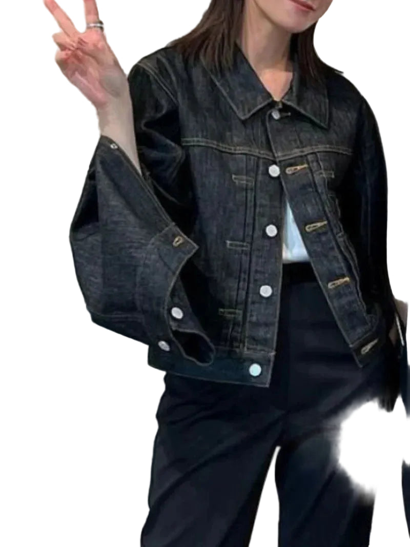 Person wearing a dark denim jacket outdoors