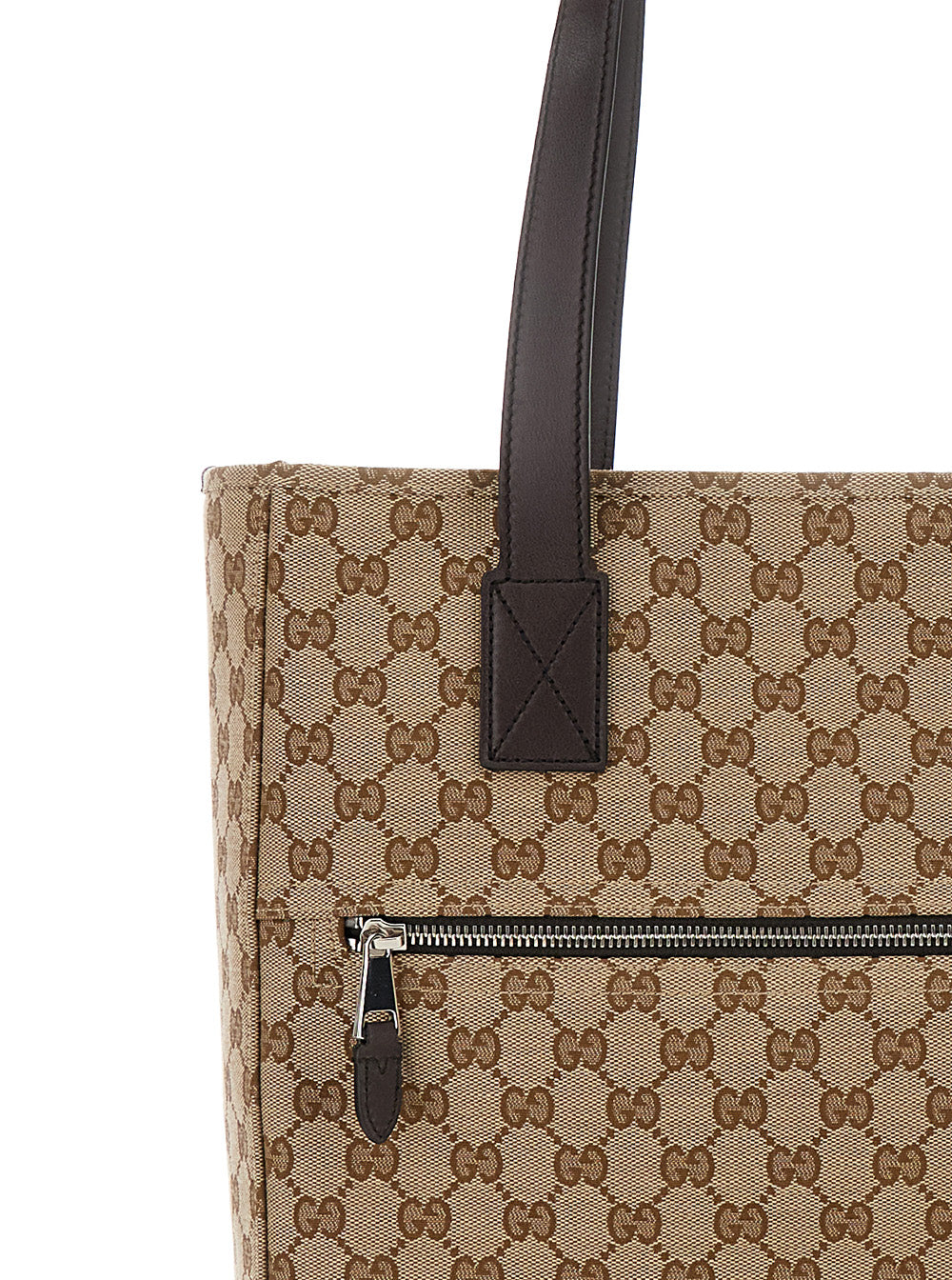 Beige handbag with brown handle and zipper on a white background