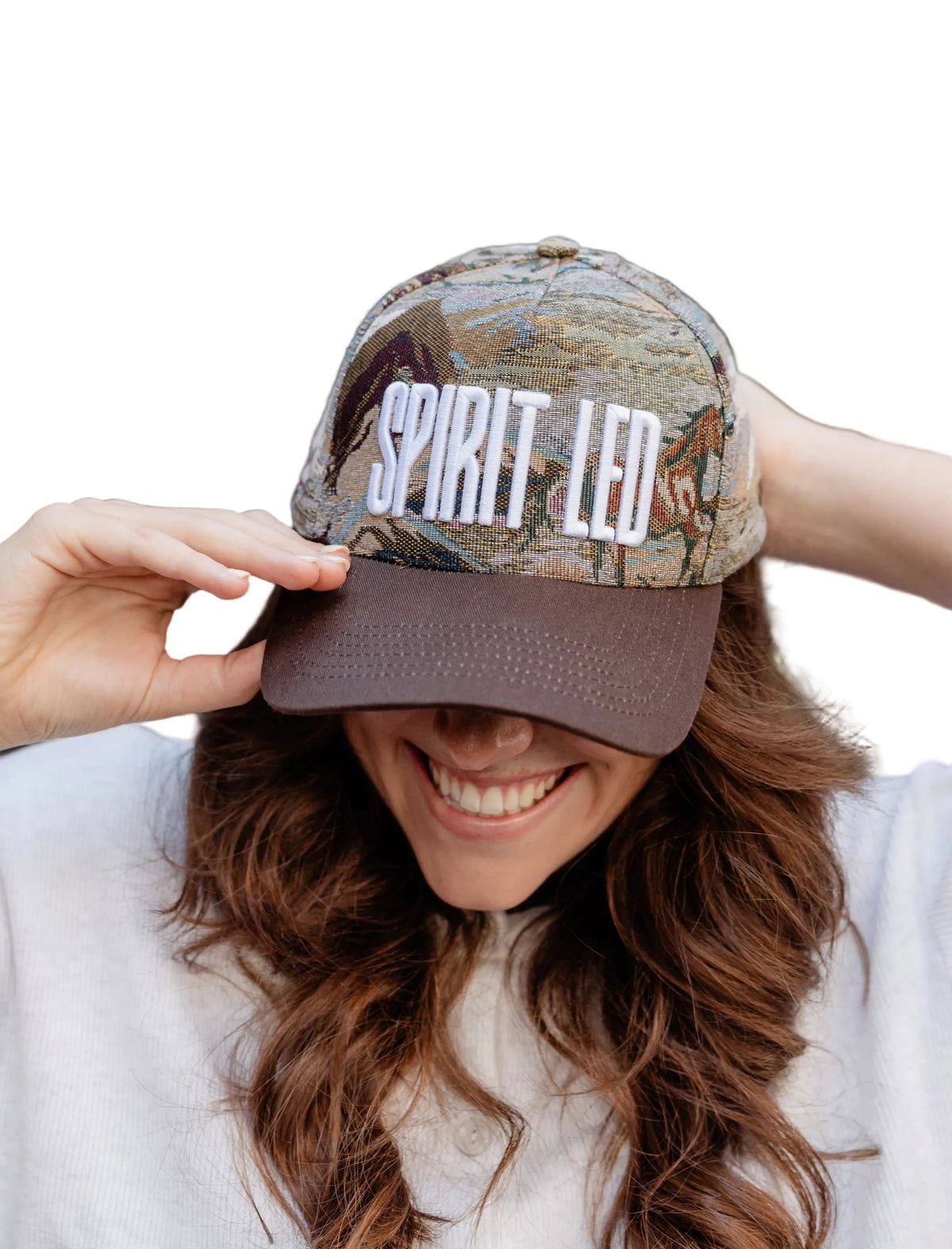 Person wearing a cap with 'SPIRIT LED' text and camouflage pattern, outdoors.