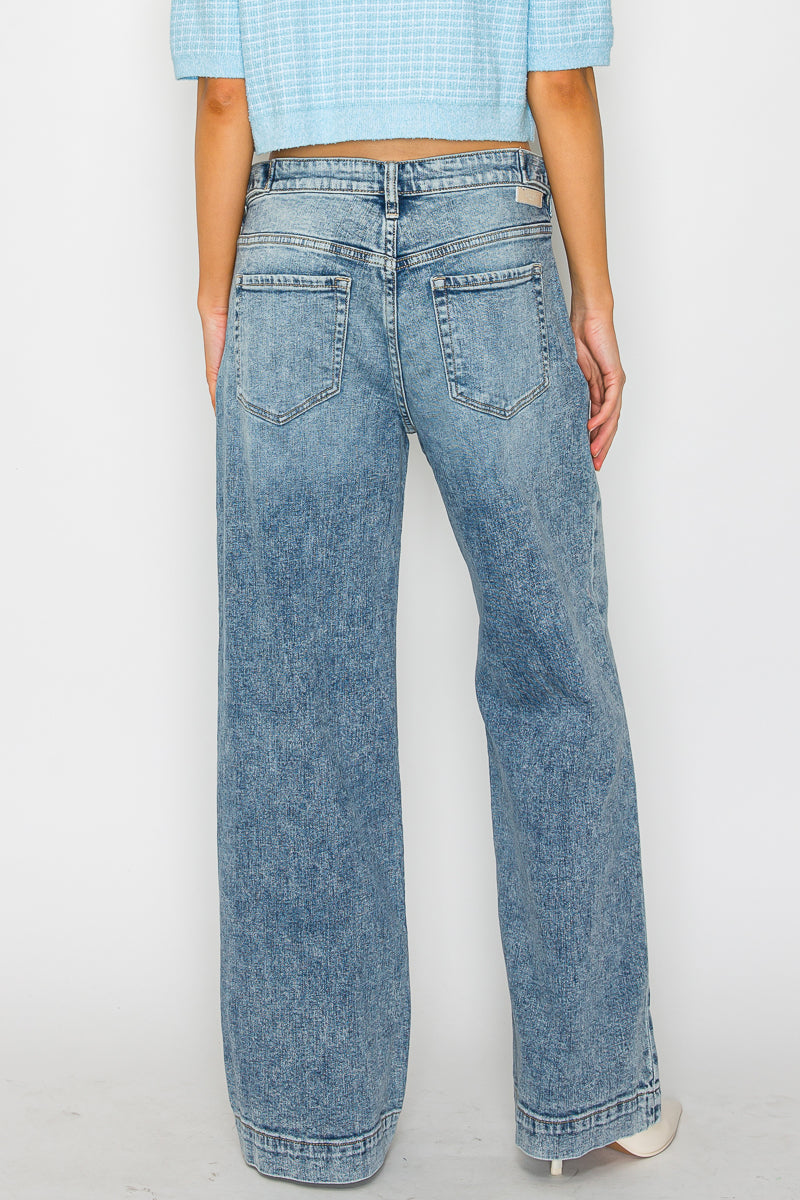 Person wearing light blue jeans and a matching top on a white background