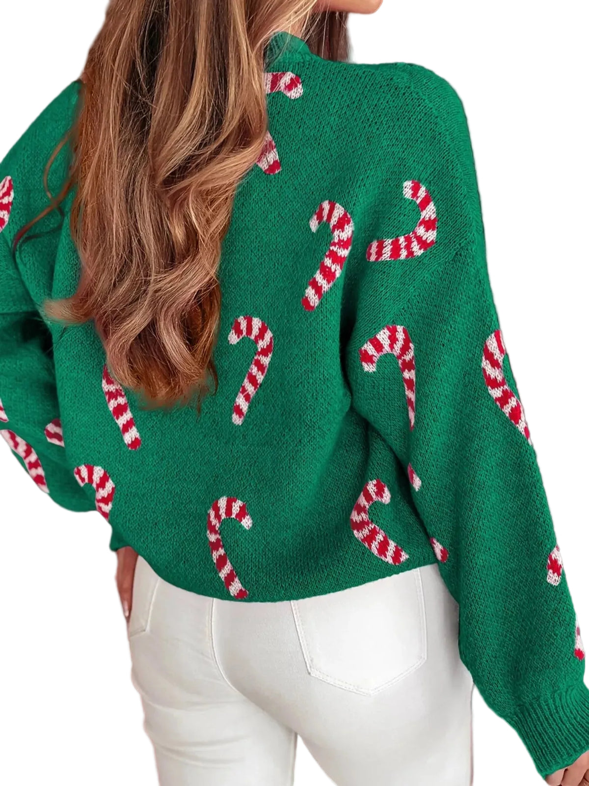 Green sweater with candy cane pattern worn by a person, against a blurred festive background.