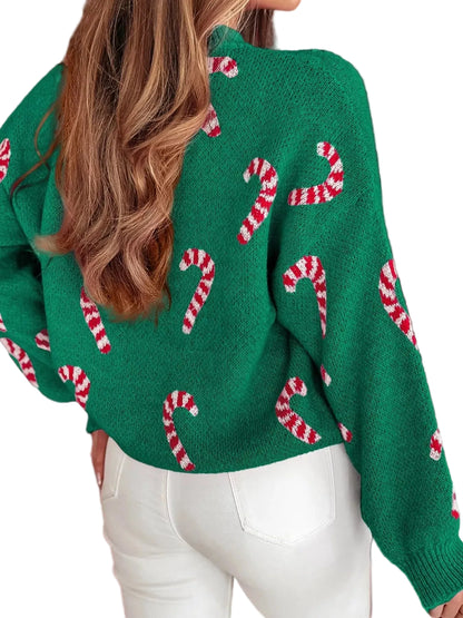 Green sweater with candy cane pattern worn by a person, against a blurred festive background.