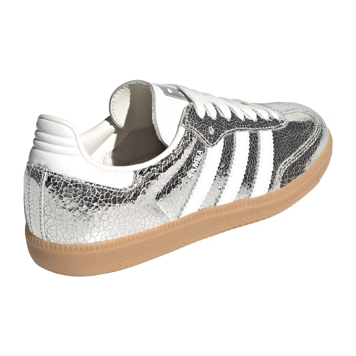 A low-top sneaker featuring a metallic silver textured leather upper with three white stripes, white laces, a white collar, and a classic gum rubber sole.