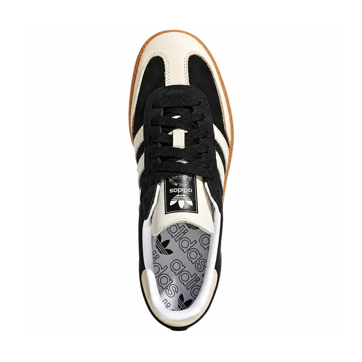 A single Adidas Samba sneaker shown from a top-down view on a solid white background. The shoe features a cream and black colorway with black laces, a black and white trefoil logo on the tongue, and a patterned gray and white Adidas Samba insole.