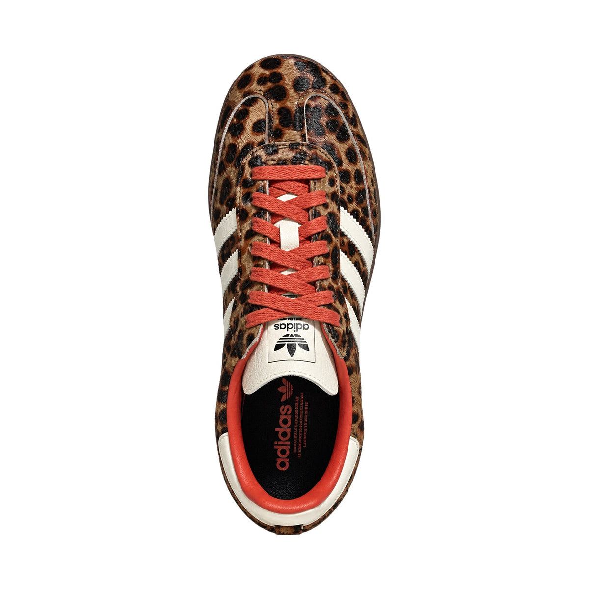 A single Adidas Samba sneaker shown from a top-down view, featuring a brown and black leopard print upper, white side stripes, white tongue and heel tabs, and coral-red laces and inner lining, set against a plain white background.