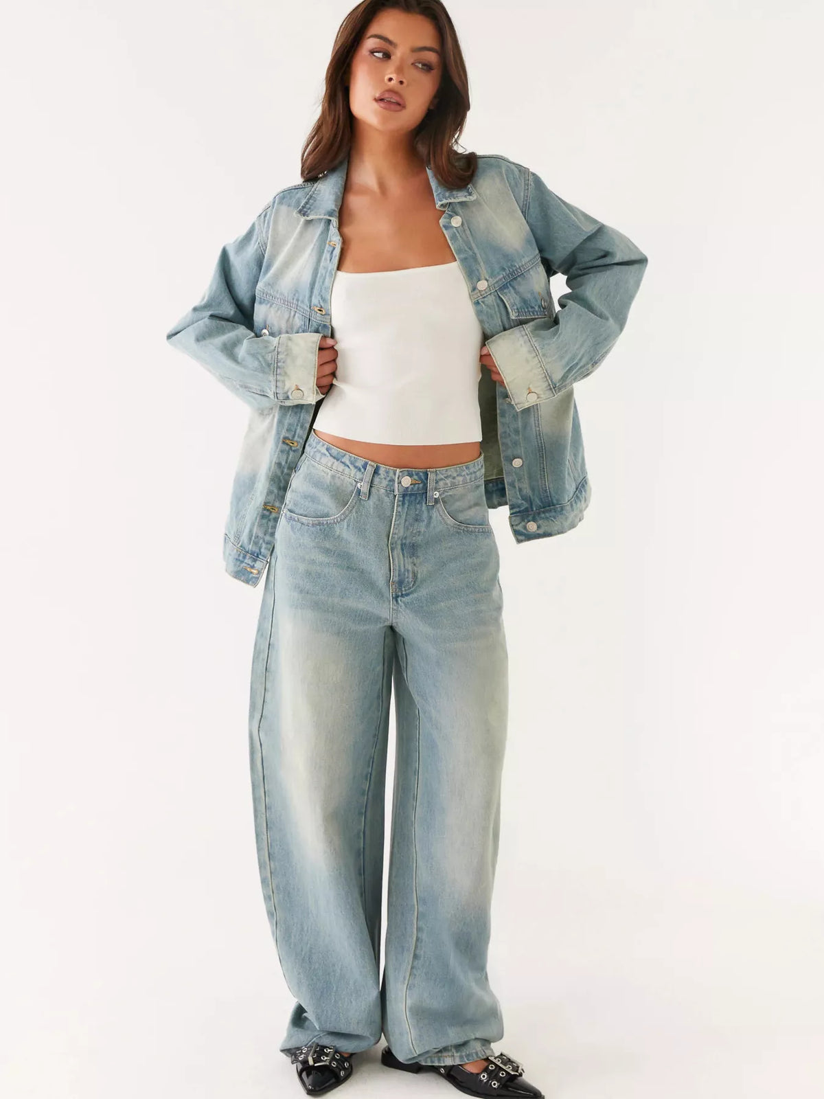 Woman wearing a denim jacket and jeans on a white background
