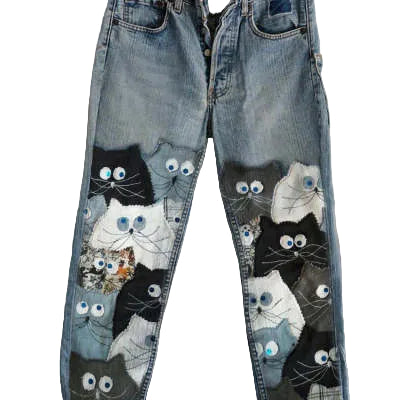 Blue jeans with cat appliqués on a plain background