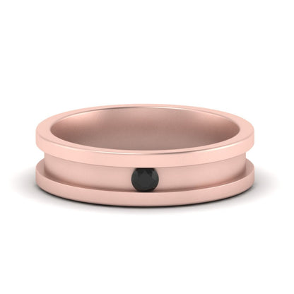 Rose gold metal ring with a black center on a white background