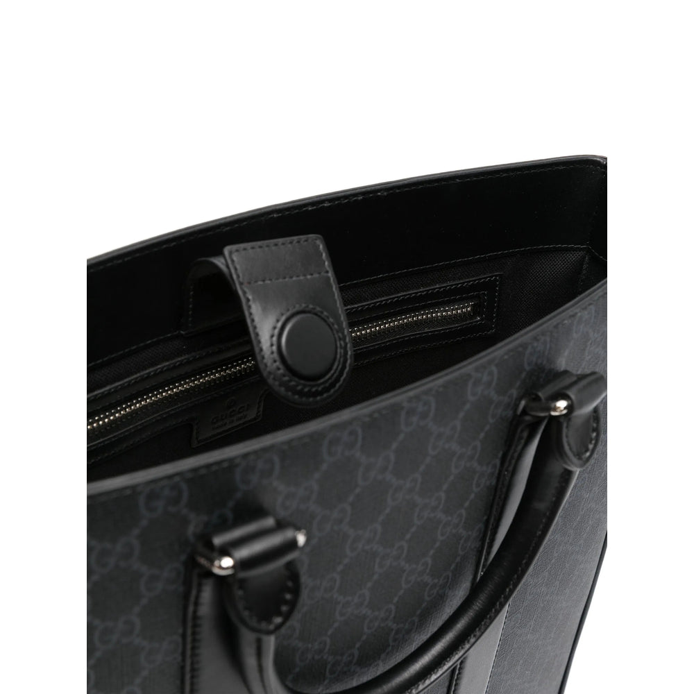 Black handbag with a patterned design on a white background