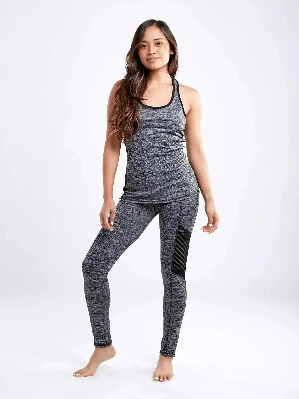 Woman wearing a gray athletic outfit on a white background
