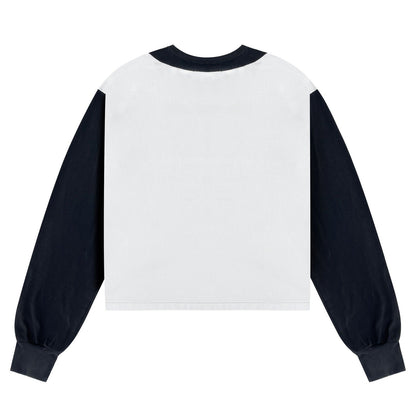 A long-sleeve crop top shown from the back, featuring a solid white back panel and contrasting dark navy sleeves, collar, and cuffs.