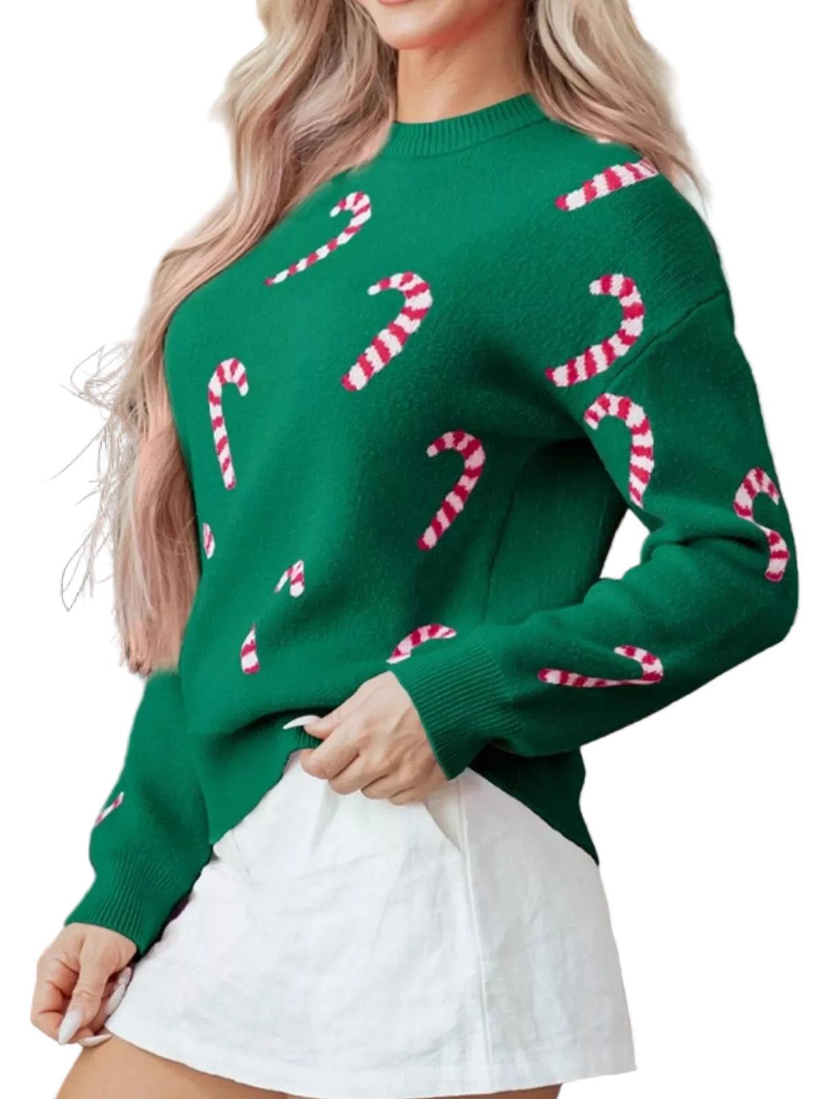 Person wearing a green sweater with candy cane patterns in front of a fireplace.