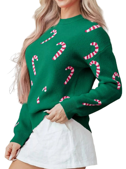 Person wearing a green sweater with candy cane patterns in front of a fireplace.