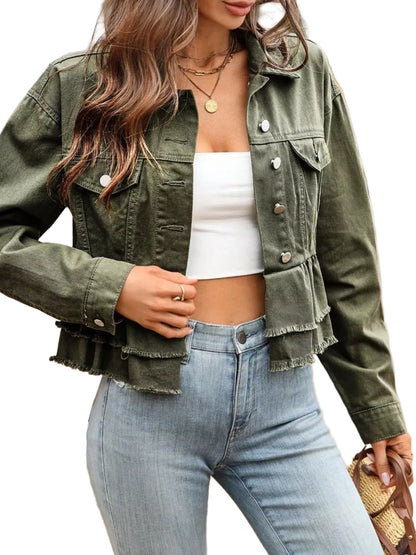 Person wearing a green denim jacket and light blue jeans outdoors.