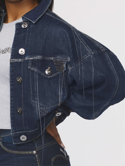 Blue denim jacket with button details on a plain background