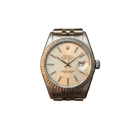Rolex Datejust wristwatch with a stainless steel fluted bezel, silver-tone Oyster bracelet, and cream dial, photographed on a dark marble surface.