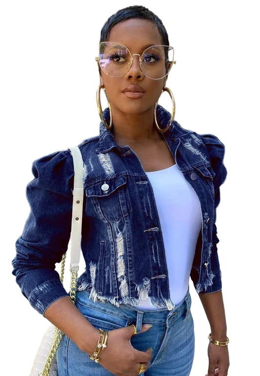 Woman wearing a denim jacket and white top in an urban setting