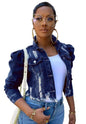 Woman wearing a denim jacket and white top in an urban setting
