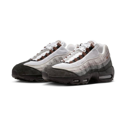 A pair of Nike Air Max 95 sneakers in a white, gray, and brown colorway, featuring a mesh upper, suede toe cap, and gradient midsole, shown against a plain white background.