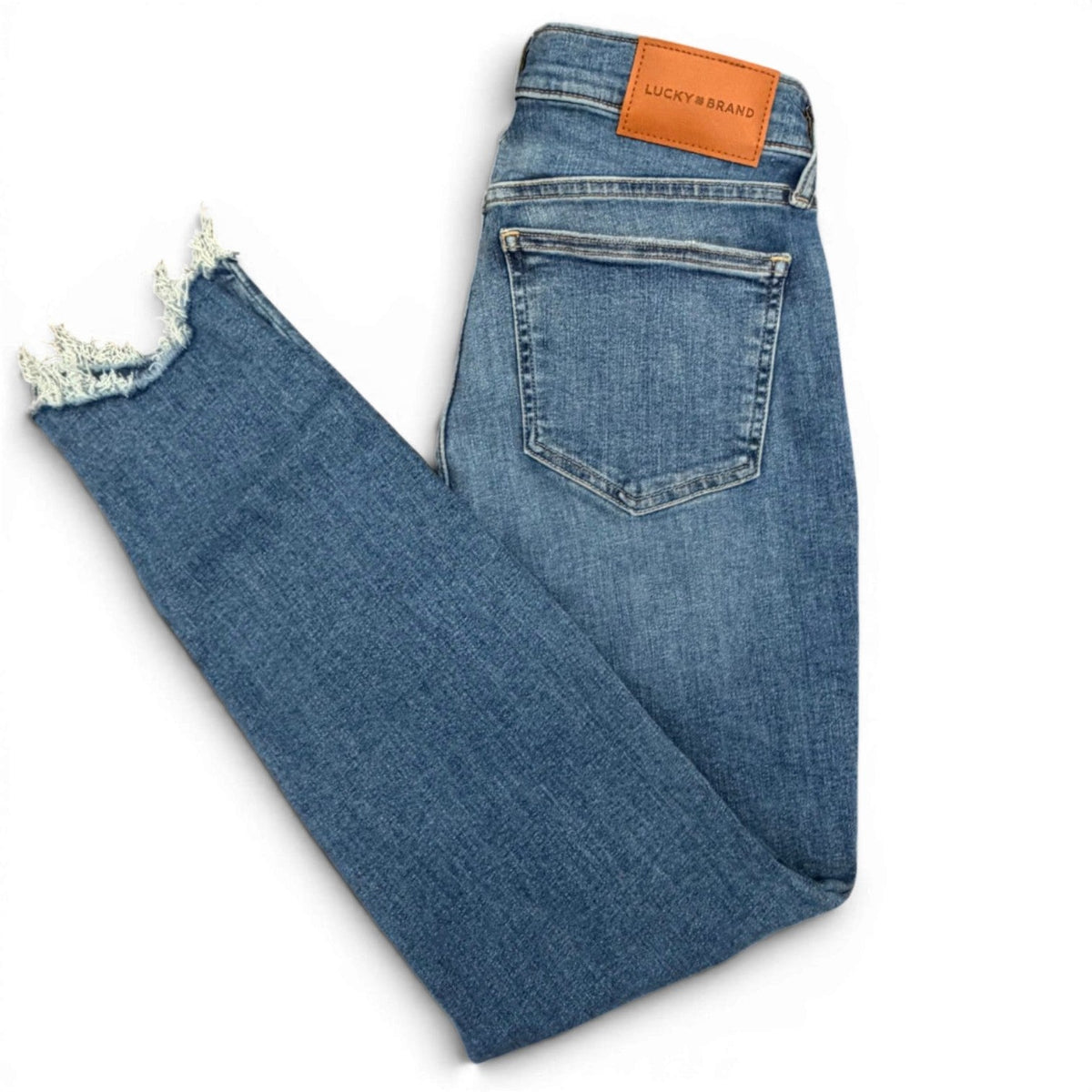 Folded blue jeans with a brand label on a white background