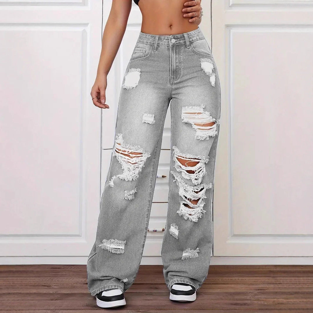 Person wearing gray distressed jeans on a white background