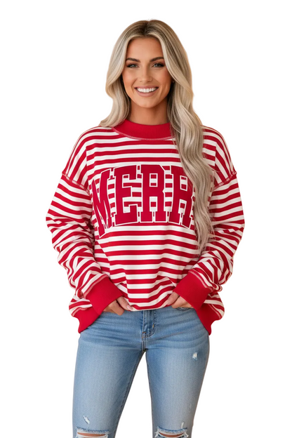 A smiling blonde woman wearing a red and white horizontally striped long-sleeve sweatshirt with 'NOLA' printed across the chest in red, paired with light blue jeans, against a solid peach studio background.