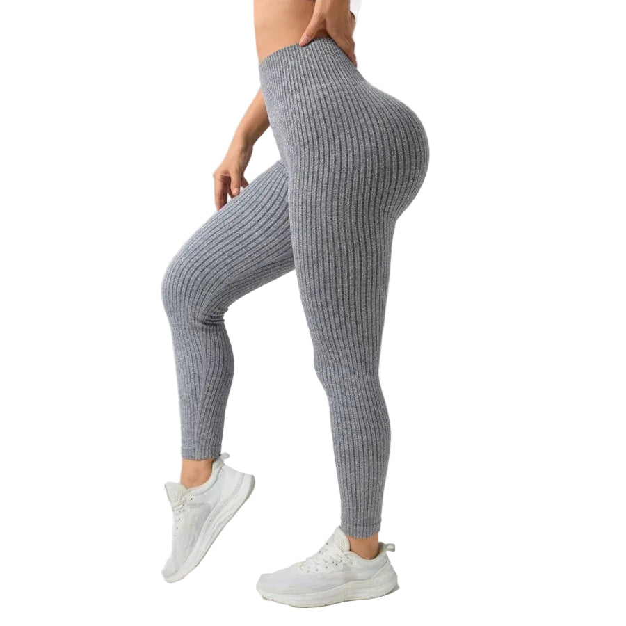 Person wearing gray ribbed leggings on a plain background
