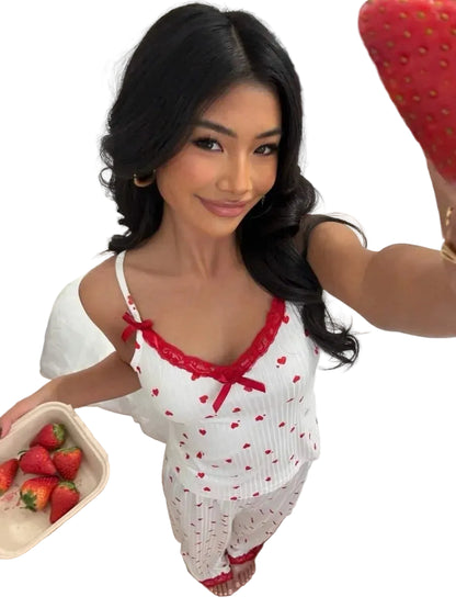Woman in a white and red outfit holding strawberries in a room.