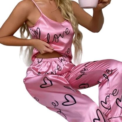 Person wearing pink satin pajamas with 'love' and heart patterns, sitting on a white couch.