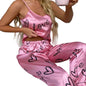 Person wearing pink satin pajamas with 'love' and heart patterns, sitting on a white couch.