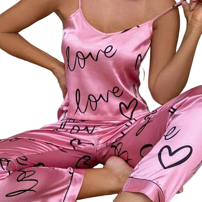 Person wearing pink satin pajamas with 'love' and heart patterns.