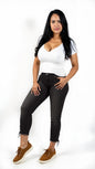 Woman wearing a white top and black jeans on a white background