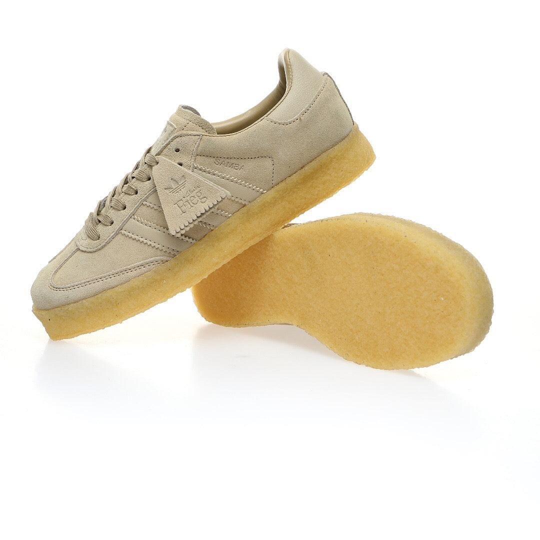 A pair of beige suede sneakers with translucent yellow soles, shown on a clean white background. One shoe is upright, and the other is turned to show the sole.