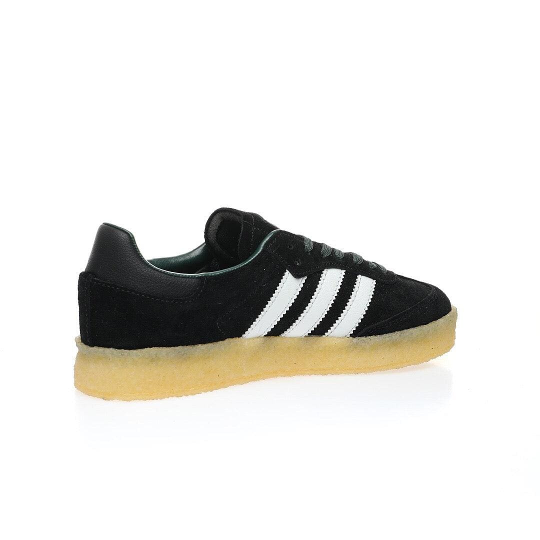 Black Adidas sneaker with white stripes on a white background
